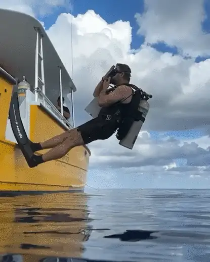 Jeffrey back-rolling off a yellow dive boat into the sea