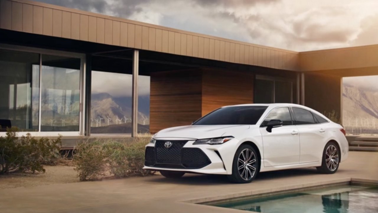 Toyota Avalon, white, beside a pool at a modern desert house